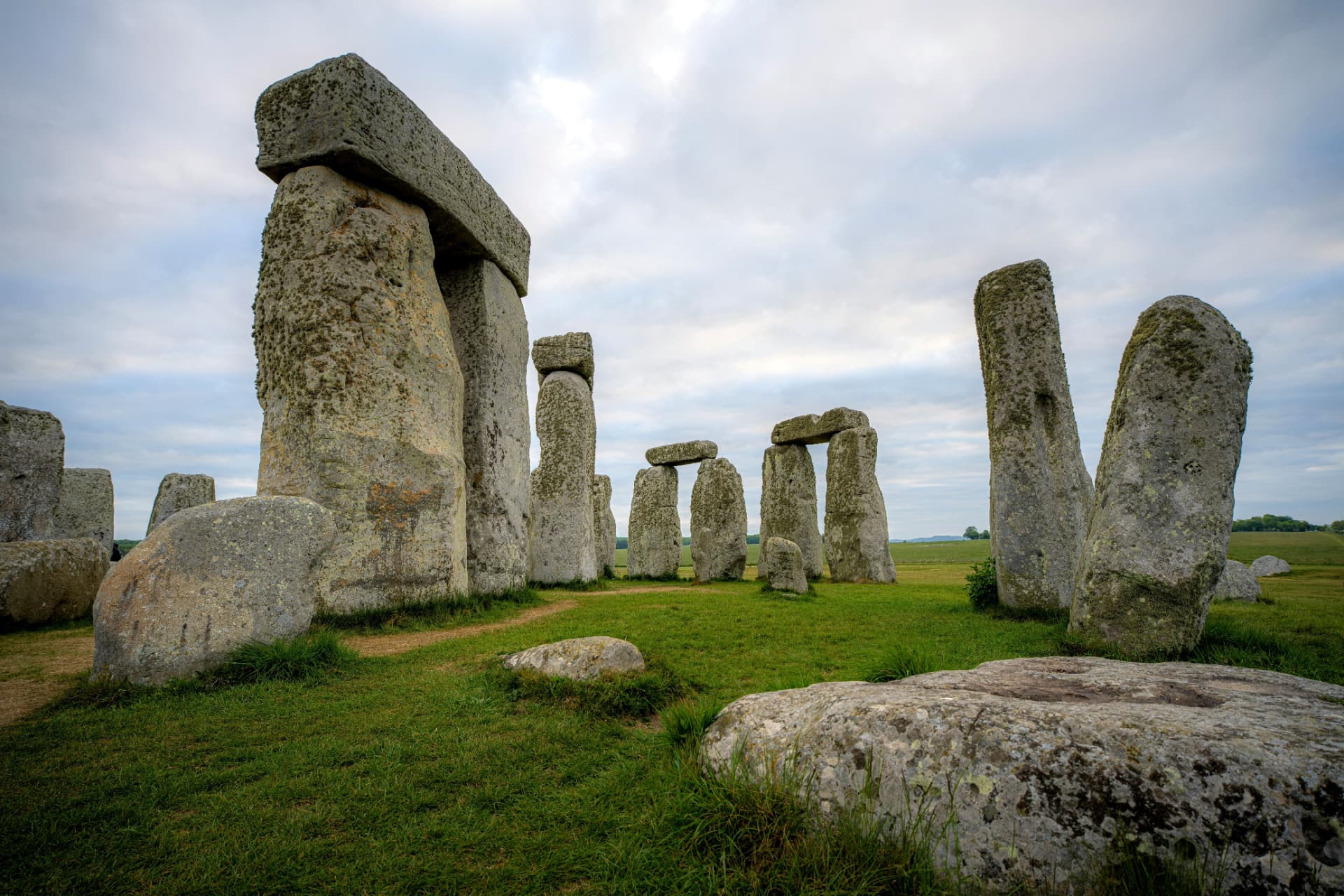 Close view of the massive weathered sarsen stones and lintels of Stonehenge under an overcast sky